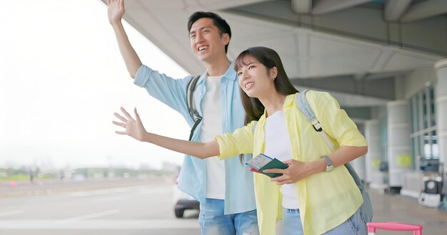 写真 空港で車を呼んでいるカップル