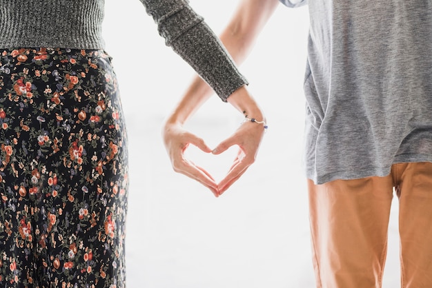 La mano delle coppie sta facendo a forma di cuore