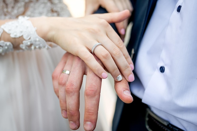 Couple hands with wedding rings. Married woman fingers with husband.