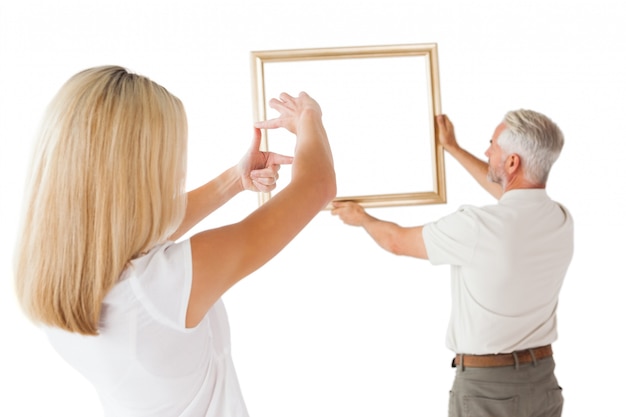 Couple hanging a frame together