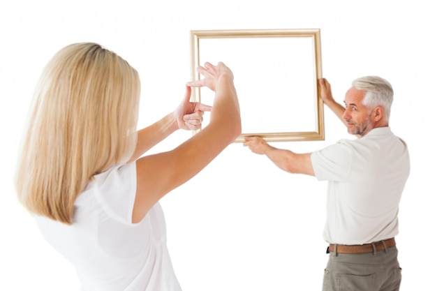 Couple hanging a frame together