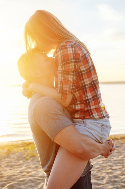 Couple happy on the beach sunset romantic kiss close-up