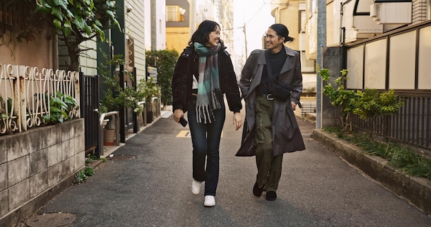 Couple happy and meeting on walk in city street and conversation with travel vacation and care Man woman and together with chat support and love on holiday on metro sidewalk in Tokyo