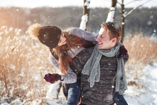 Couple has fun and laughs. kiss. Young hipster couple hugging each other in winter park. Winter love story, a beautiful stylish young couple. Winter fashion  with boyfriend and girlfriend