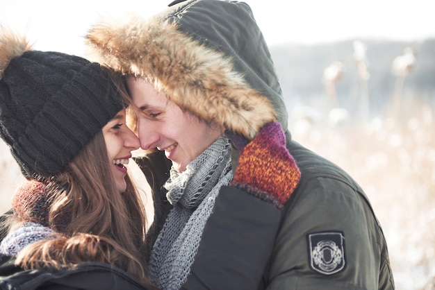 Photo couple has fun and laughs. kiss. young hipster couple hugging each other in winter park. winter love story, a beautiful stylish young couple. winter fashion  with boyfriend and girlfriend