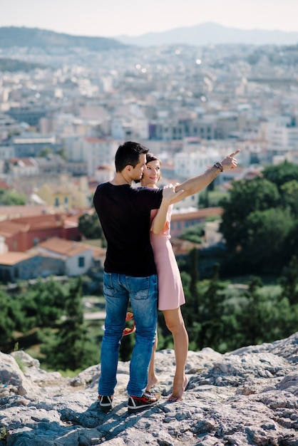 Couple have a date on the peak of the hill with panorama view on the city kissing each other