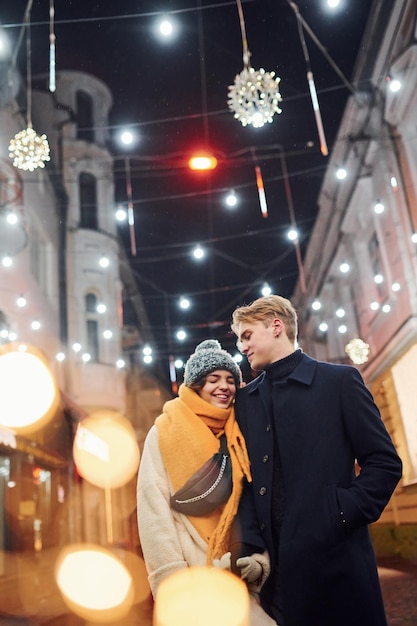 Couple have a walk together on the christmas decorated street.