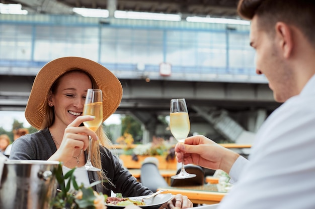 屋外レストランで素晴らしいランチとシャンパンを飲むカップル