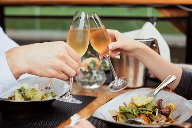 Foto coppia che pranza e beve champagne al ristorante all'aperto