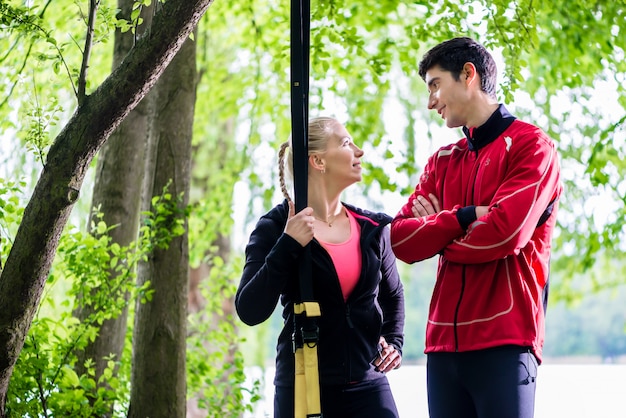 Couple having break from sling training