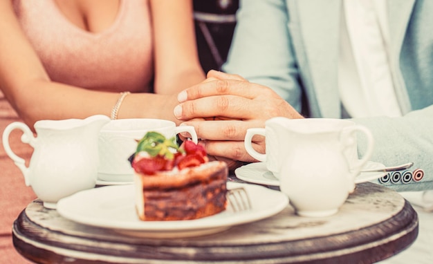 Photo couple in having coffee in cafe young couple drinking cappuccino at bar coffee shop happy romantic couple sitting in a cafe drinking coffee