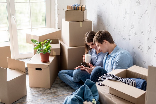 Couple having coffee while packing to move house