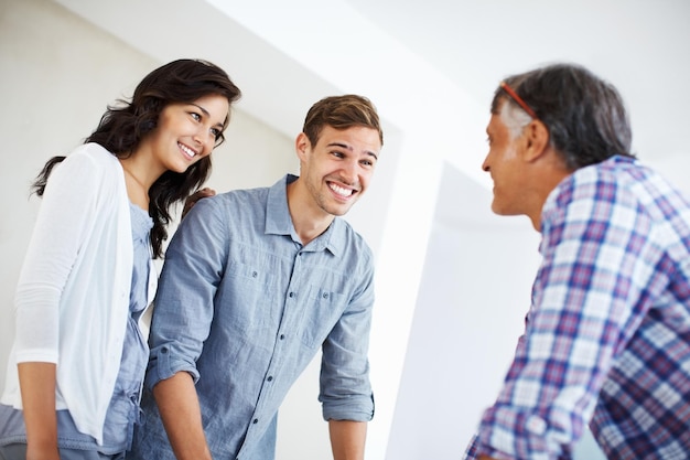 Couple having conversation with architect Young couple having conversation with mature architecture