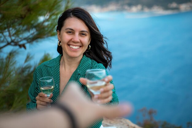 Couple having date on the cliff with view of sea bay at Greece island