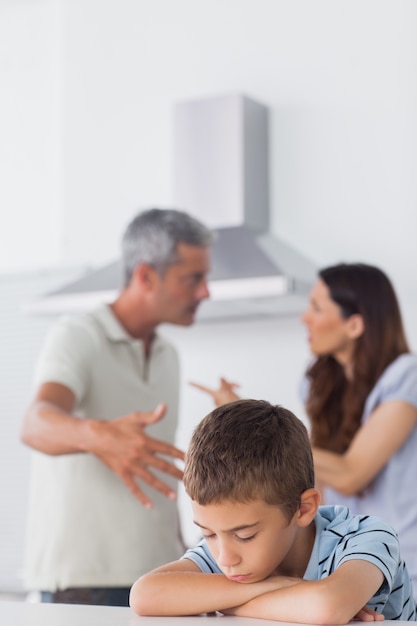 Photo couple having dispute in front of their sad son