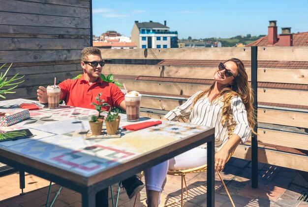 Photo couple having a drink on a terrace