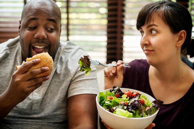 Photo couple having fast food on the couch