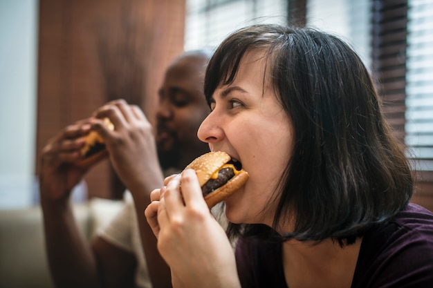 Photo couple having fast food on the couch