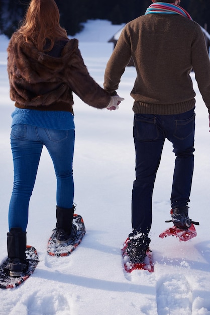 Photo couple having fun and walking in snow shoes