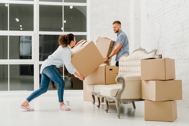 Couple having fun while sorting boxes