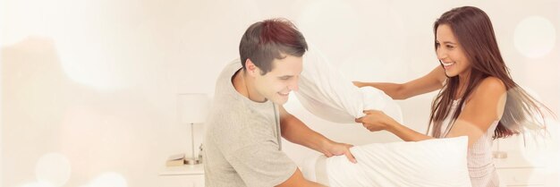 Couple having fun with a pillow fight in bed