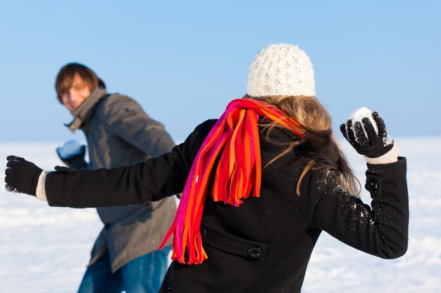 Foto coppie che hanno lotta a palle di neve