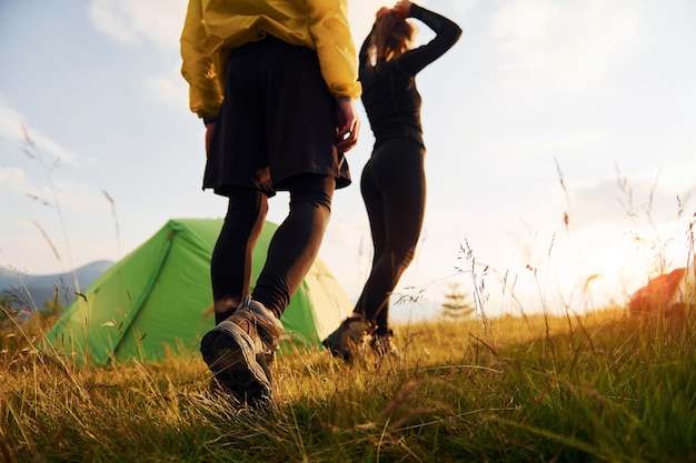 Coppia fare una passeggiata all'aperto vicino alla tenda verde concezione di viaggiare