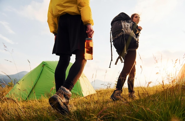 녹색 텐트 근처에서 야외에서 산책하는 커플 여행의 개념