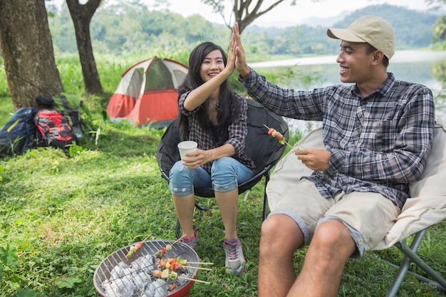 Couple high five while enjoying camping