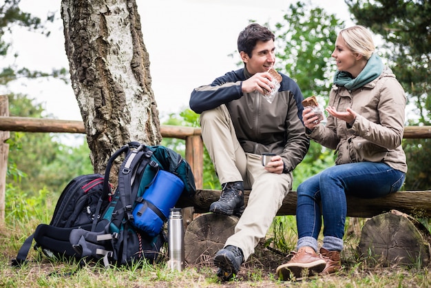 Couple on hike taking rest under tree 