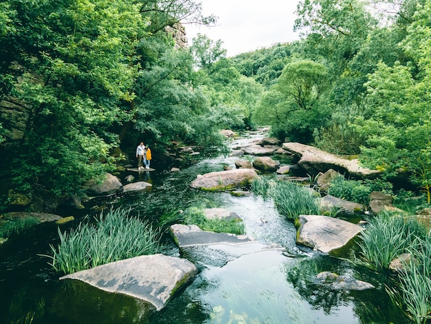 Couple hiker at canyon river beach enjoying the view copy space