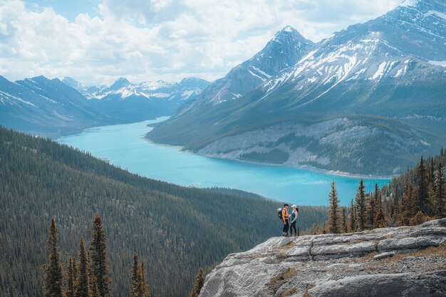 A couple hikers standing on a hill overlooking a beautiful spray lakes of kananaskis alberta