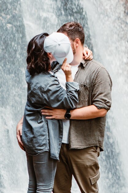 Couple hikers tourists looking at waterfall copy space