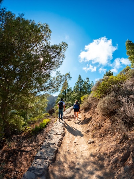 Photo a couple of hikers on the trail up to roque nublo in gran canaria canary islands vertical photo