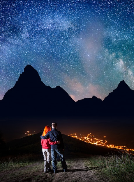 couple on hill under the bright stars