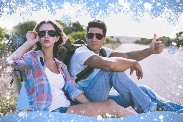 Photo couple hitchhiking on countryside road against snow