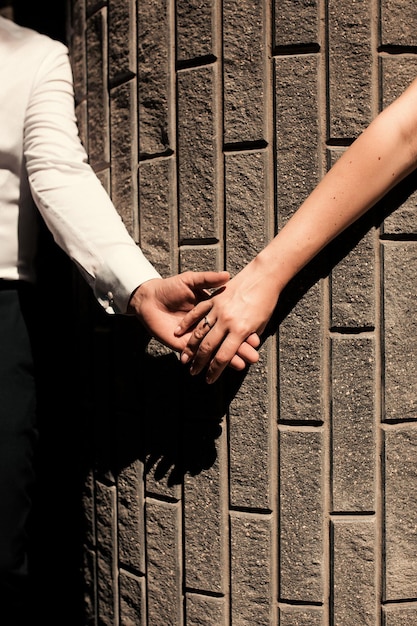 Couple hold hands on a background of stone background Wedding Bride and groom Wedding rings