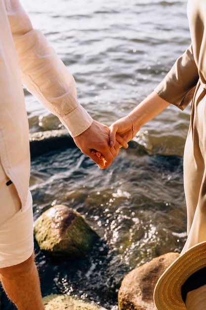 Photo couple hold hands in green field on sunset