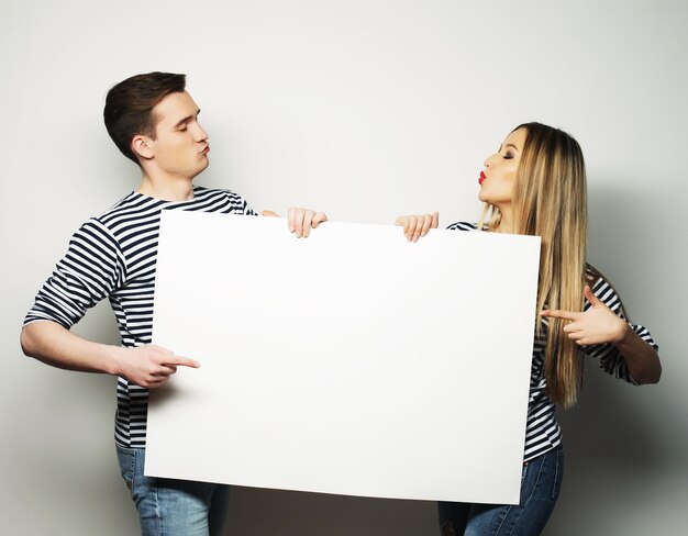 Couple holding a banner isolated over a white background