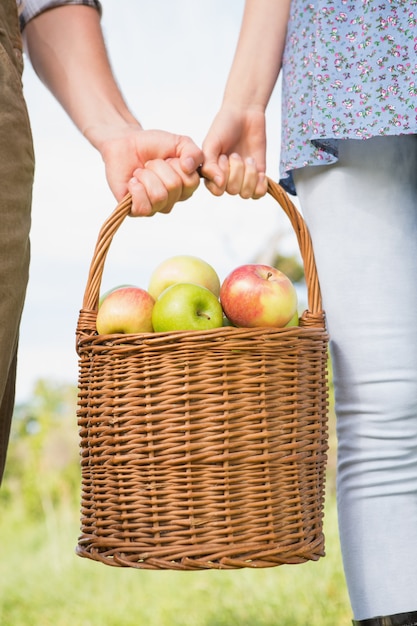 Couple holding basket of apples