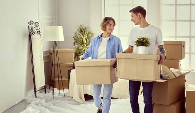 Photo couple holding boxes for moving the hands and looking inside box