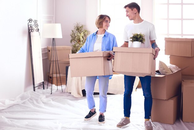 Couple holding boxes for moving the hands and looking inside box