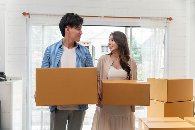 Photo couple holding cardboard boxes for moving to a new house