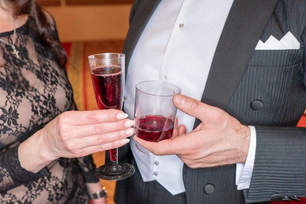 A couple holding glasses of red wine and a glass of champagne