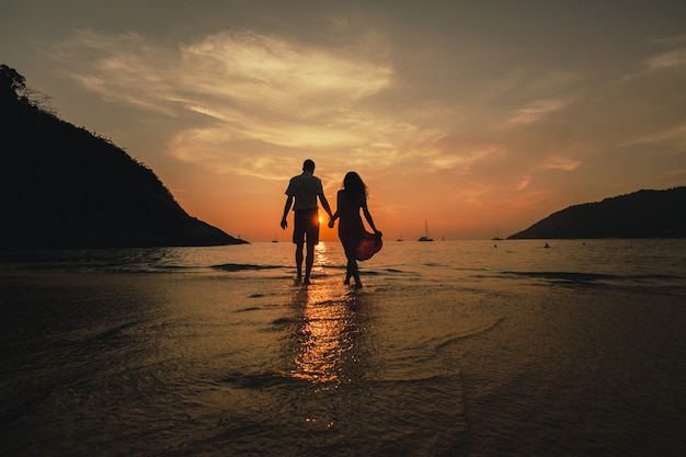 Couple holding hands on the beach