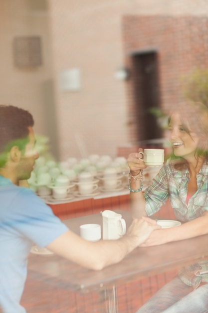 A couple holding hands and drinking coffee