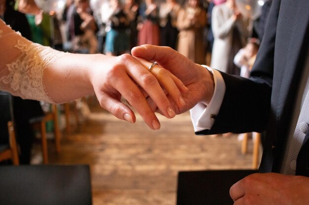 Photo couple holding hands during wedding ceremony