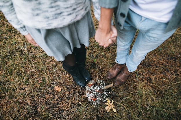 couple holding hands in the forest