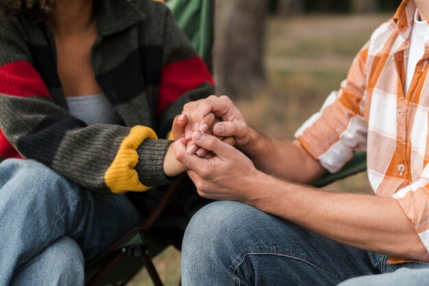 Couple holding hands outdoors while camping