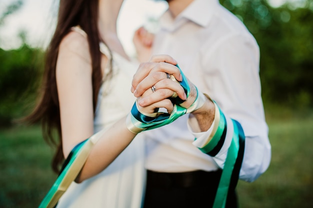 Couple holding hands tied up with ribbon